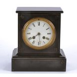 A Victorian black marble cased mantel clock, white enamel dial with Roman numerals on a pediment