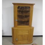 An Alan Solly contemporary two section oak corner cupboard, the upper section having a moulded