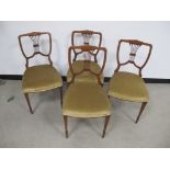A set of four Edwardian walnut chairs, shaped backs with pierced back splats, raised on tapering