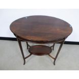An early 20th Century mahogany two tier occasional table, oval top with decorated edge, raised on