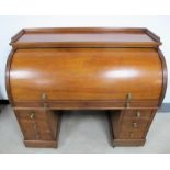 A Victorian mahogany knee hole roll top writing desk, gallery top with a cylinder front, fitted