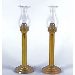 A pair of brass candlesticks, column design, with clear glass storm shades, height 33cm (2)