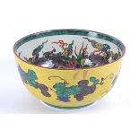 A large Asian bowl, possibly Japanese, the exterior glazed in yellow and decorated with scrolling