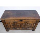 An antique oak and elm coffer, two plank top with a moulded edge, architectural front, three