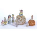 Two early 20th century porcelain pin cushion dolls, together with four other half-dolls and a pair