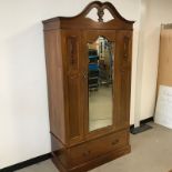 An Edwardian mahogany wardrobe, pierced cornice above single door with mirror with moulded flowers