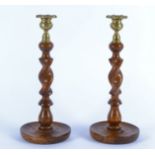 A pair of spiral turned oak candlesticks, with brass sconce, on circular dished bases, height 31.5cm