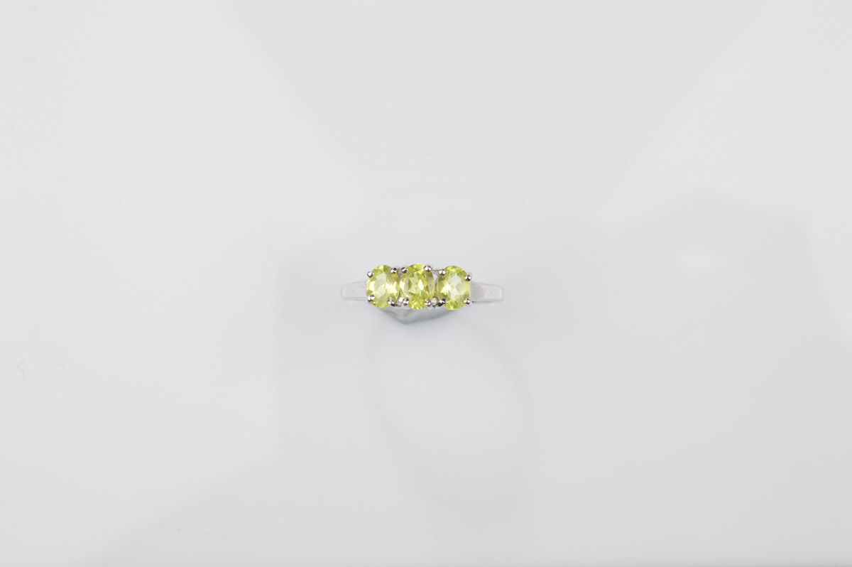 A certificated 9ct gold chrysoberyl three stone dress ring, oval mixed cuts in claw setting in white