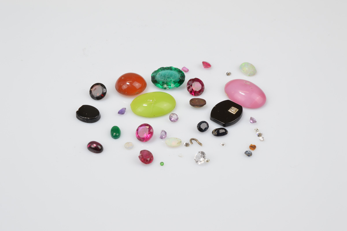 A small collection of loose gem stones, including precious opal, onyx and diamond barrel cut tablet,