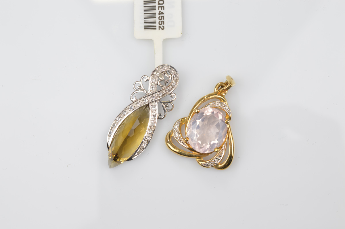 A certificated 9ct gold rose quartz and diamond pendant, the oval mixed cut claw set central stone