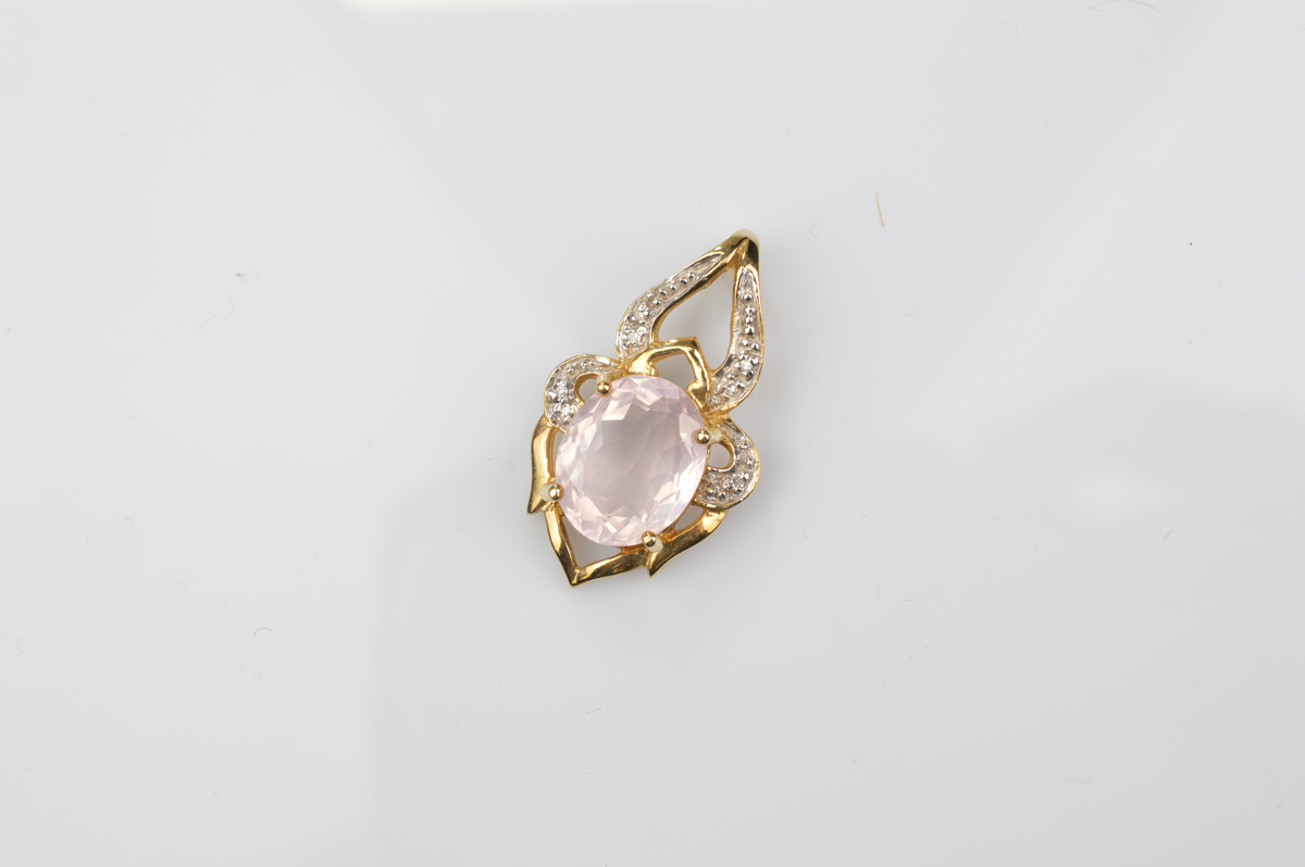 A certificated 9ct rose quartz and diamond set yellow gold pendant, the rose quartz oval mixed cut