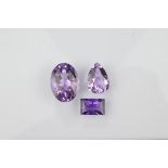 Three certificated loose amethysts, comprising a Uruguayan baguette cut 7.8ct, an oval 27ct and a