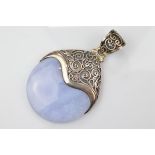 A certificated blue lace agate and silver pendant, the polished disc encased in filigree mount