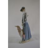 A large Lladro porcelain figure, featuring a windswept woman with a dog and parasol. 41Cm tall.