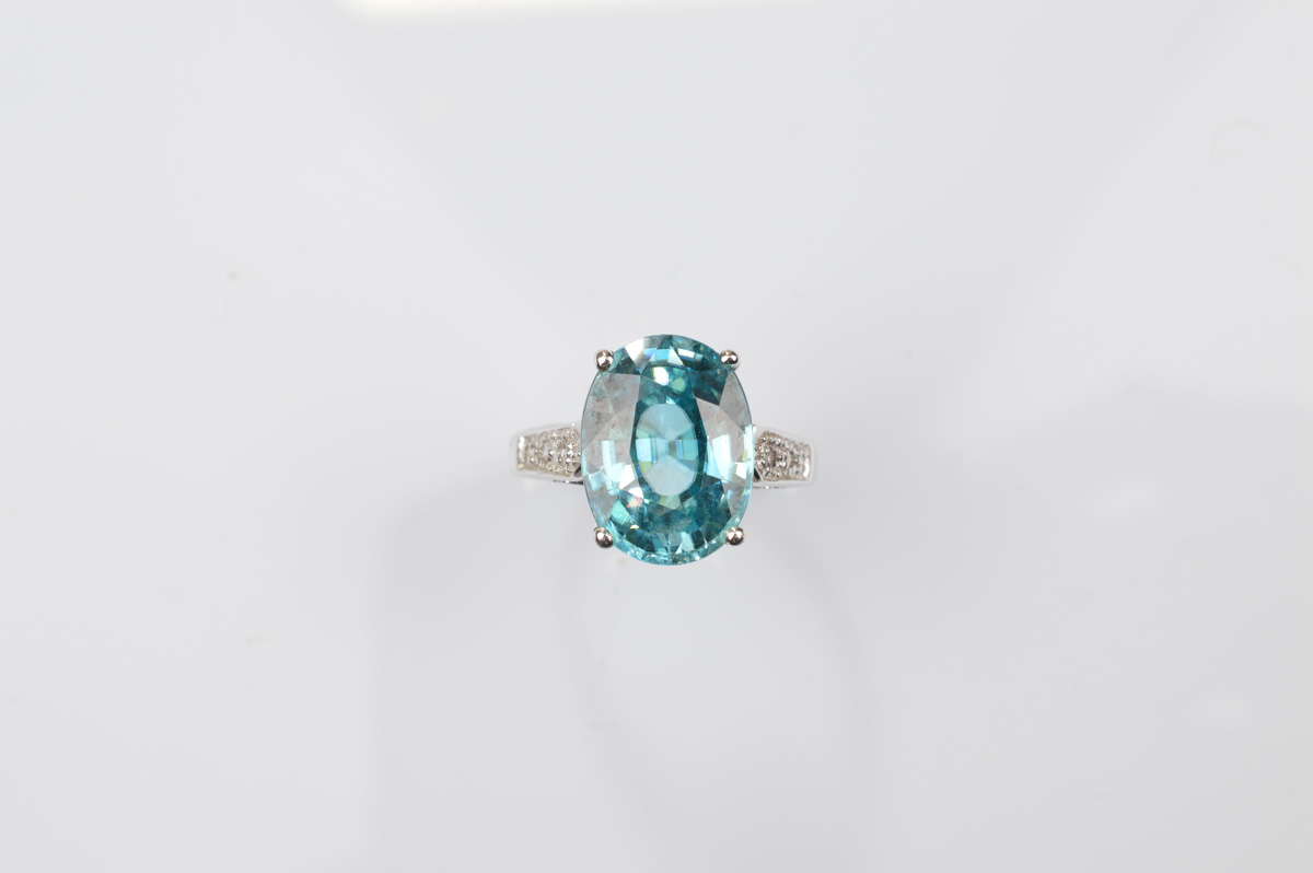 A certificated 9ct gold zircon and white topaz dress ring, the oval mixed cut blue zircon with white