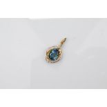 A certificated 9ct gold London blue topaz and diamond set gold pendant the oval mixed cut topaz in