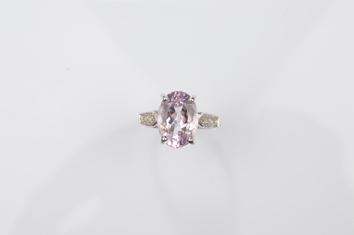 A certificated 9ct gold Brazilian kunzite and diamond white gold dress ring, the oval mixed cut claw