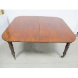 A 19th Century mahogany dining table, drawer leaf action, rounded top with two extra leaves,