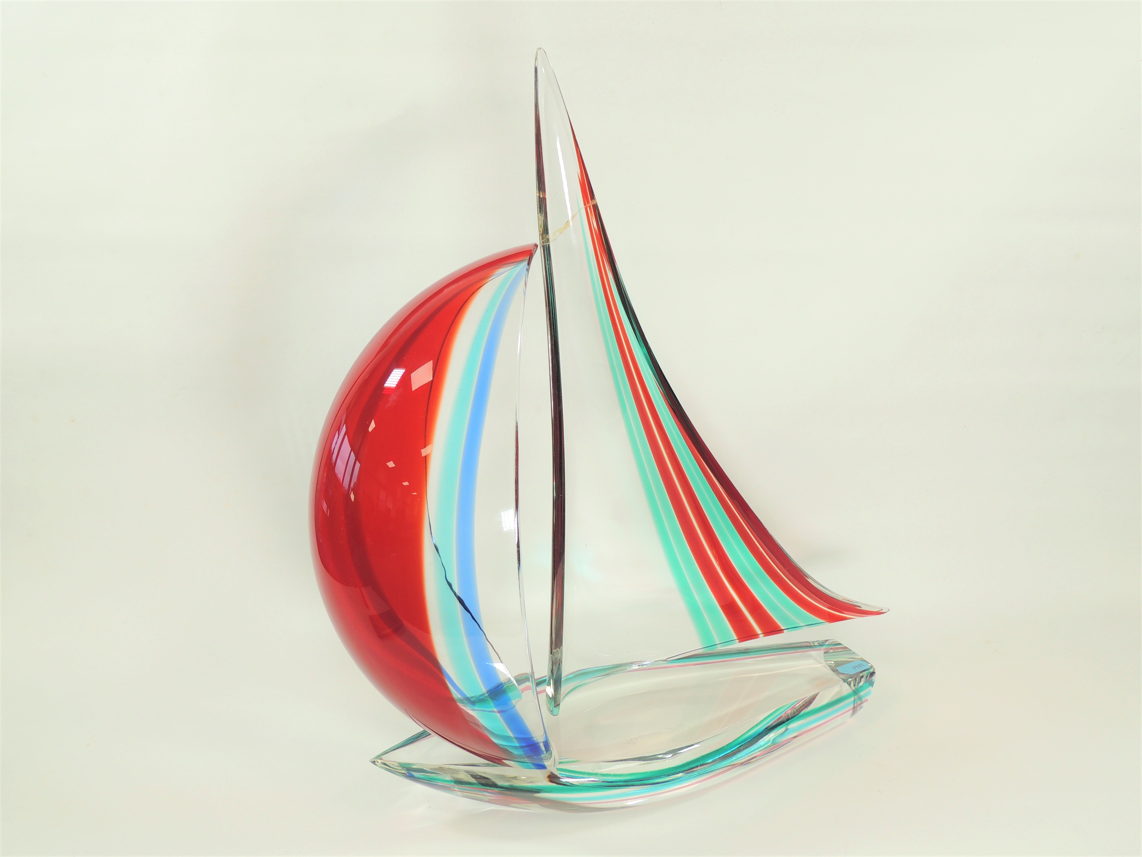 An Italian Murano glass sculpture of a sailing boat, with encased red, blue and green colouration,