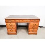 Leather topped oak twin pedestal desk, with four drawers to either side and single central drawer to