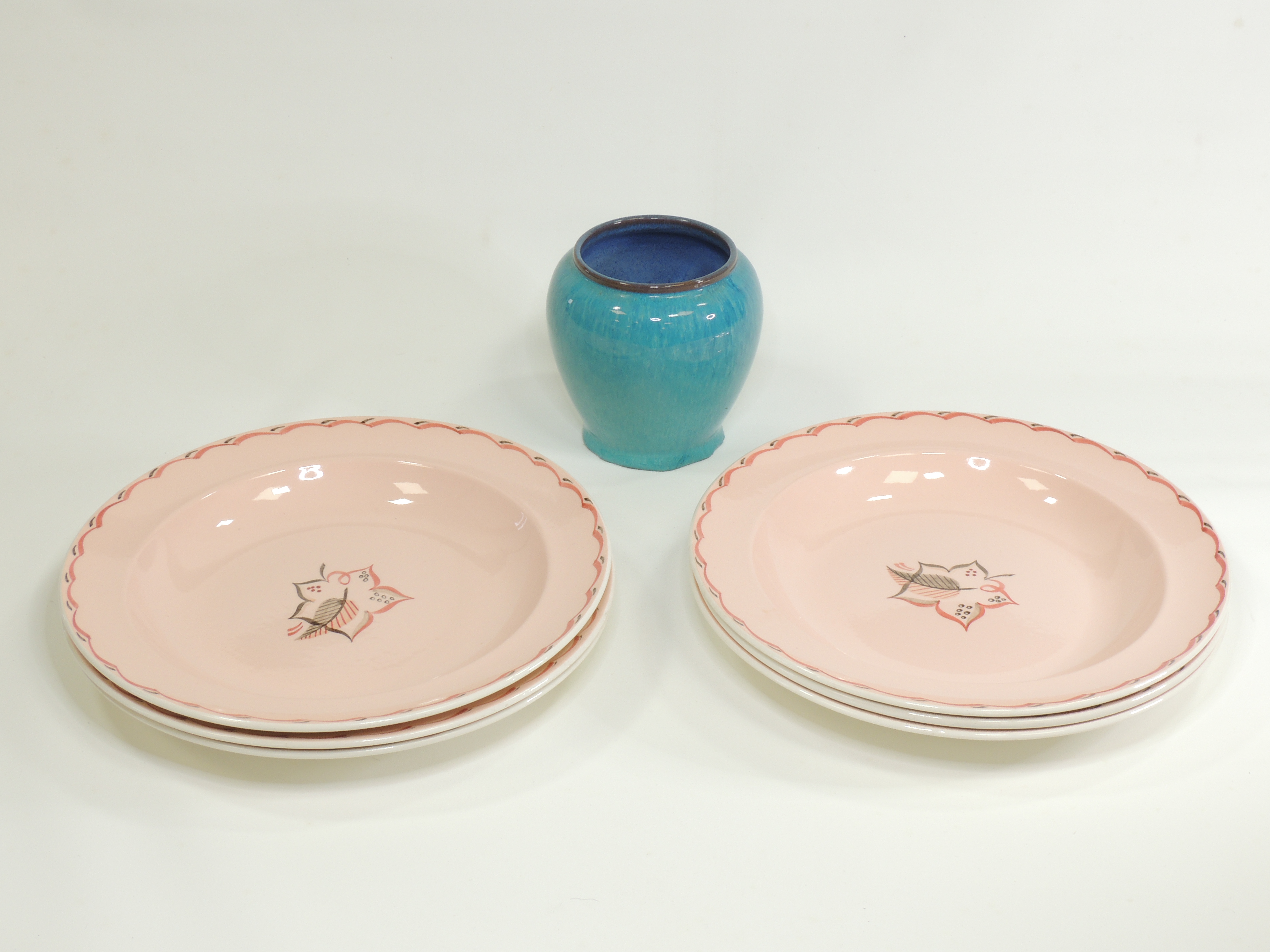 Six mid 20th Century Poole pottery plates hand painted with stylised leaf motifs, the base with