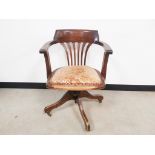 Edwardian oak adjustable revolving captains chair, set on a four leg base with brass castors, with