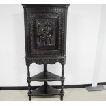 A stained oak carved 20th century corner cupboard on stand, top section having a moulded cornice,