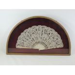 A late 19th Century lace fan framed and glazed, the decorative lace panel stretched across