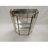 A mirror backed collectors' or retailers' display cabinet, in a trapezoid prism shape with one