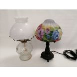 A contemporary lamp with a naturalistic design and a shade decorated with butterflies and flowers,