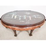 20th Century mahogany oval table of oriental design, with glass top and decorative resin inserts