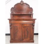 A Victorian mahogany chiffonier, shaped back with applied carving, a shelf supported by two turned