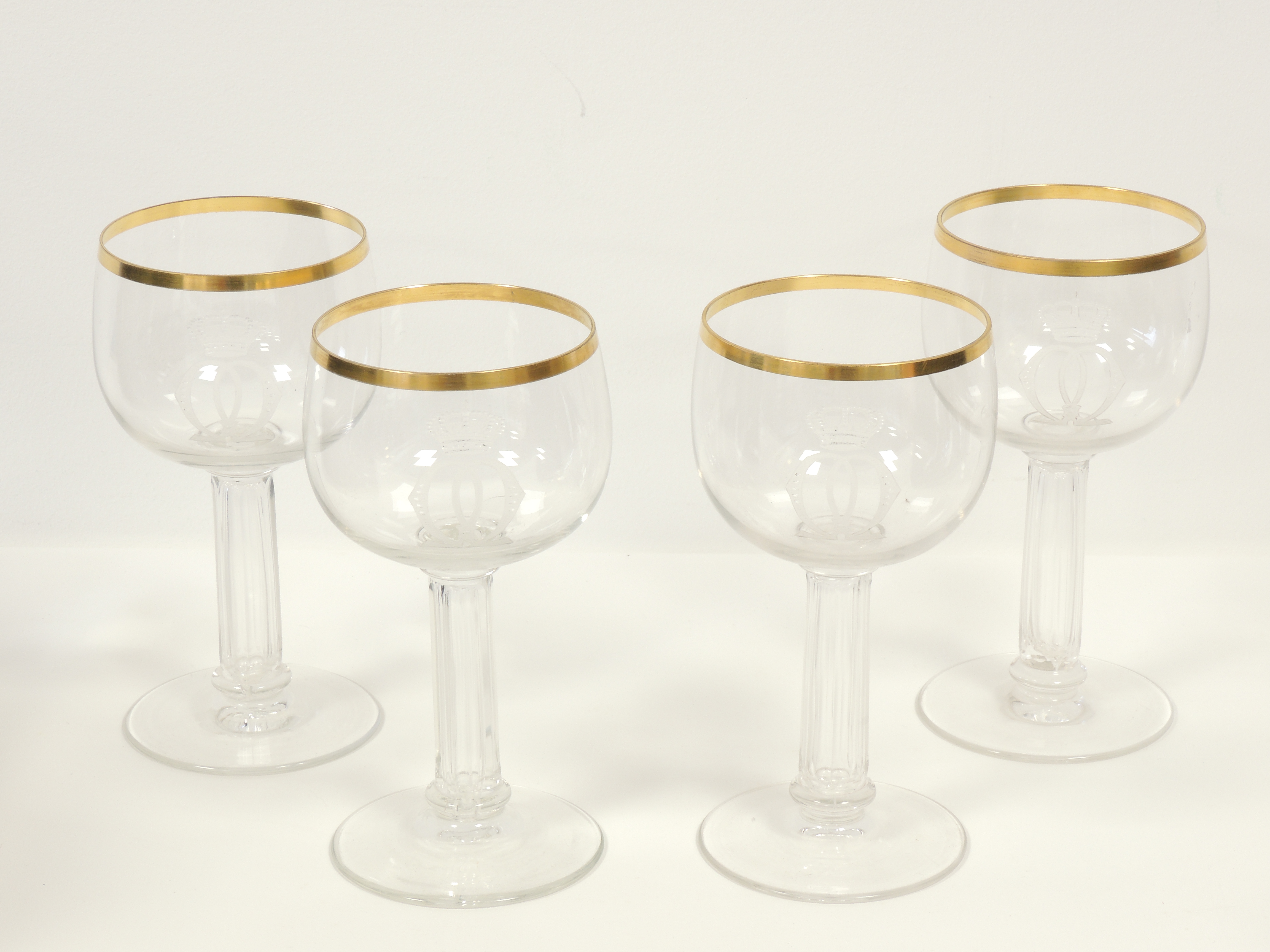 Four German glasses with engraved interlaced decoration surmounted by crowns, raised on multifaceted