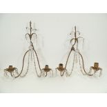 A pair of gilt metal twin wall sconces with strung hanging lustres, the bowls in the form of open