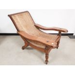 A 19th century teak Planters chair, rattan seat, working leg supports, raised on turned front