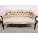 19th Century button backed settee, with woven floral upholstery, raised on four wooden legs having