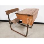 Early 20th Century pine school desk, with built in folding chair on a bent metal frame.