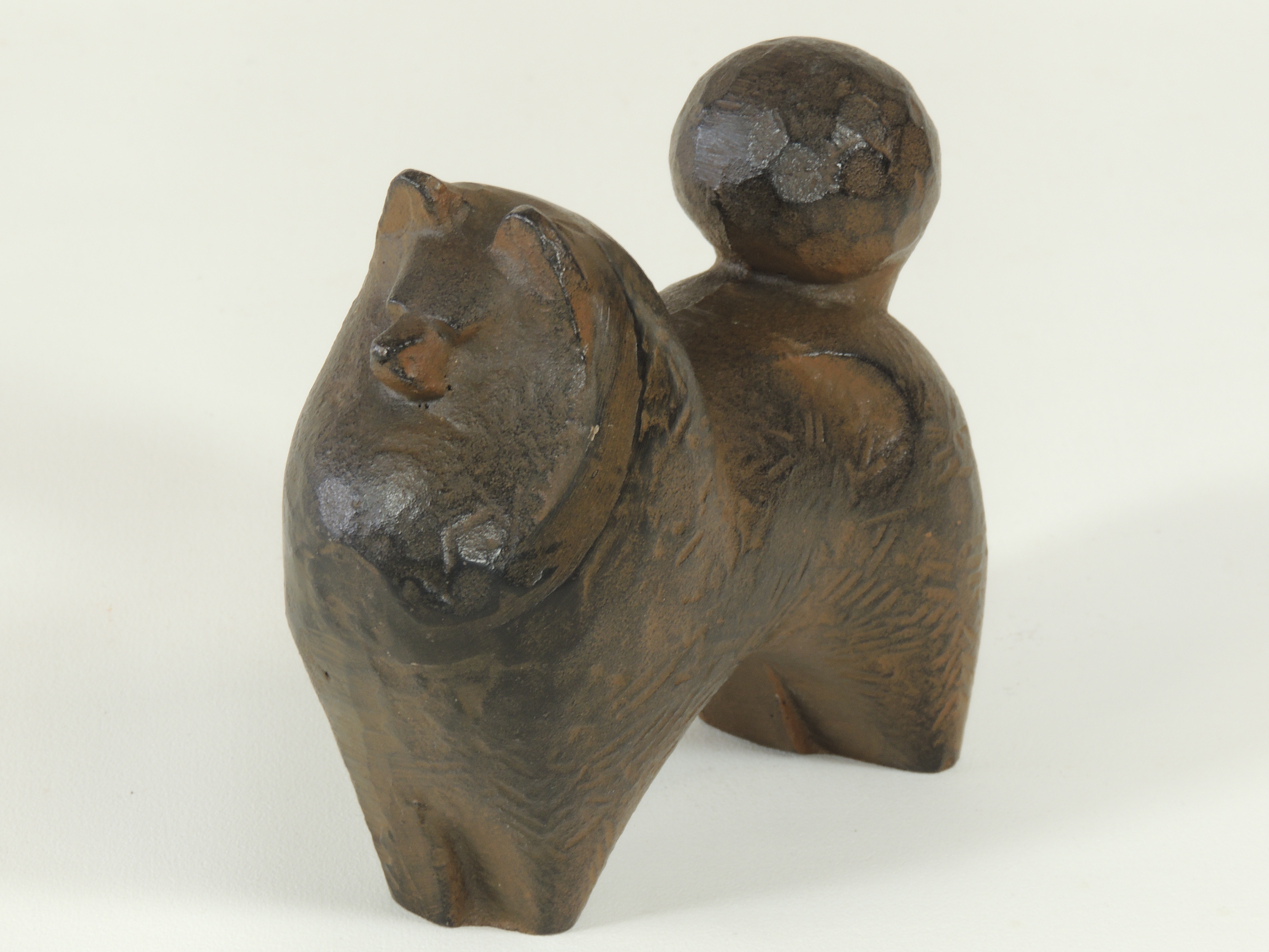 A 20th Century cast metal figure of a Pomeranian type dog, with impressed foundry mark to bag