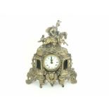 A 20th Century German brass cased clock surmounted by a horse rider, raised on scrolling feet with a