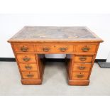 Oak leather topped twin pedestal writing desk, with central frieze drawer and four drawers to each