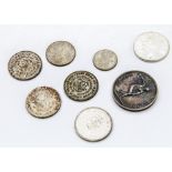 A collection of world coins, including three Mexican one peso, two Canada dollars, and more, also