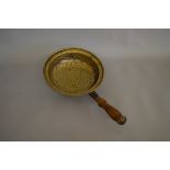 A Victorian brass and turned wooden handled drainer or strainer, the circular brass bowl with