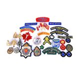 A collection of Canadian metal and cloth badges, to include 2nd Queen's Own Rifles of Canada,