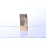 A 14k gold Dunhill Rollalite pocket lighter, with vertical line decoration, with roller to side,