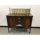 A late Victorian or Edwardian mahogany sideboard, with brass rail and curtain, 118cm wide and