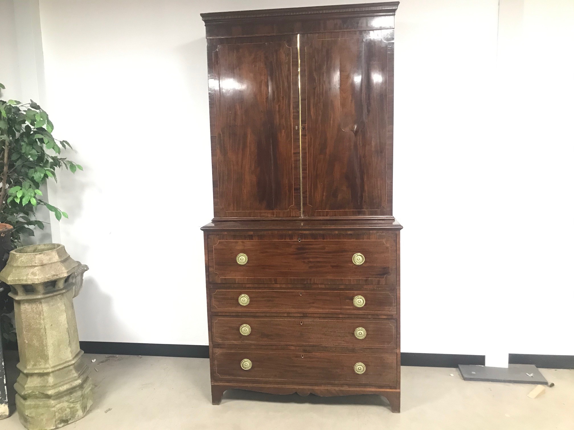 A late Georgian mahogany secretaire linen chest, having upper section with panel doors above