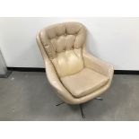 A c1970s egg style chair, in cream vinyl, on five spoke spinning and reclining base