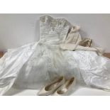 A wedding dress from Benjamin Roberts, size 12, together with a short ivory material dress by Ronald