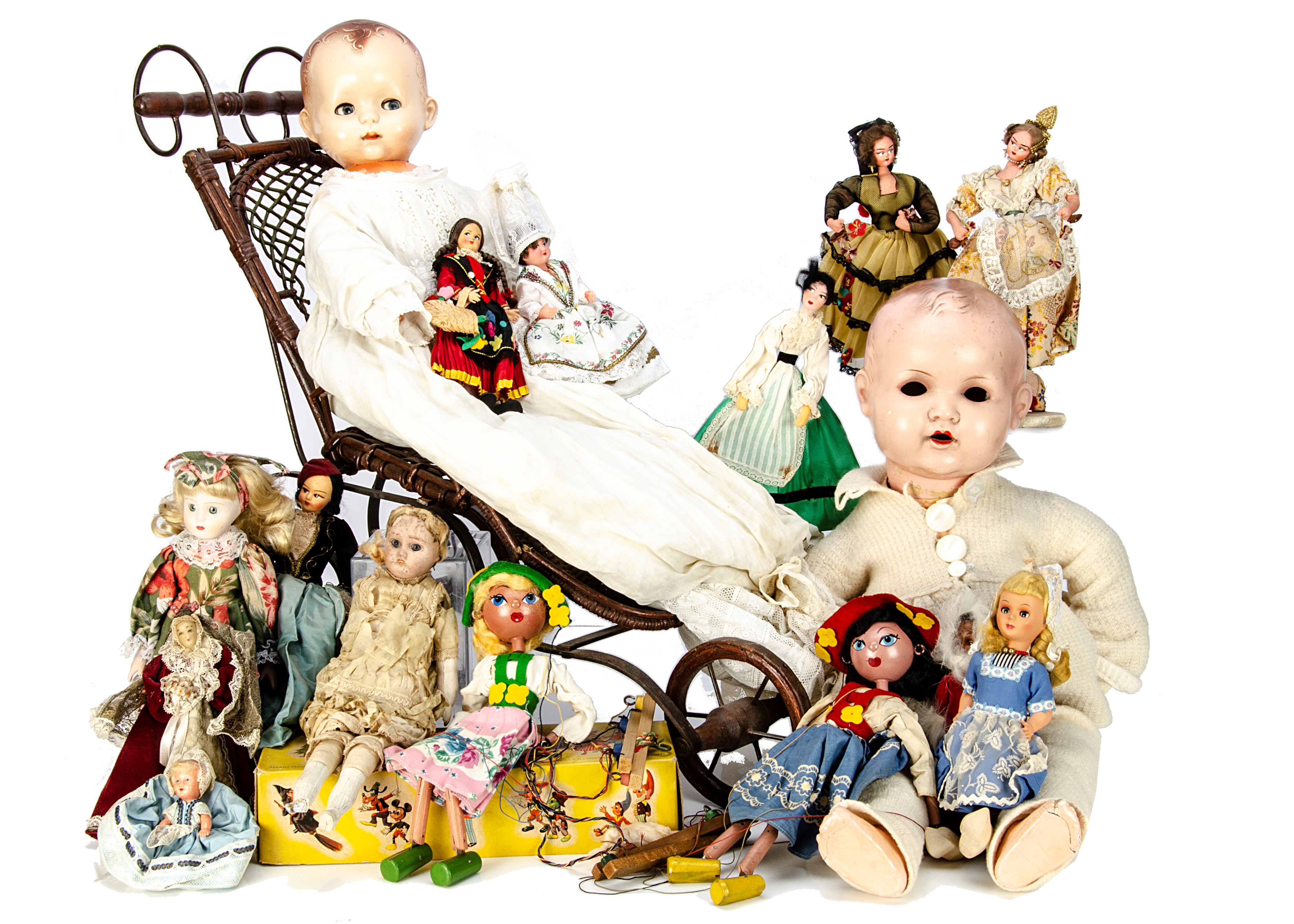 A collection of vintage dolls,  together with a reproduction wicker dolls' push chair, 64cm high,