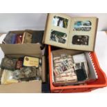 A collection of collectables, including cigarette and trade cards, postcards, a postcard album,